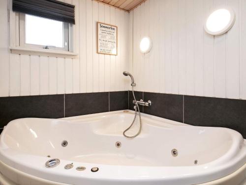 una vasca bianca in un bagno con finestra di 12 person holiday home in L kken a Løkken