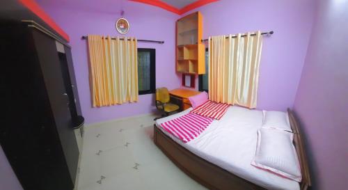 1 dormitorio con 1 cama en una habitación con paredes rosas en VISAVA Home Stay, en Alibaug