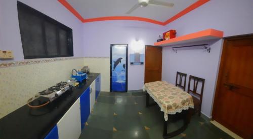 Habitación con cocina con mesa y fogones. en VISAVA Home Stay, en Alibaug