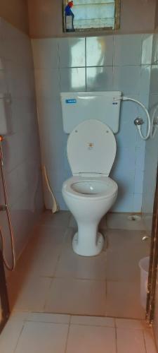 a bathroom with a white toilet in a room at VISAVA Home Stay in Alibaug