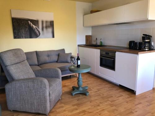a kitchen and a living room with a couch and a table at Anton, FW 9 in Zingst