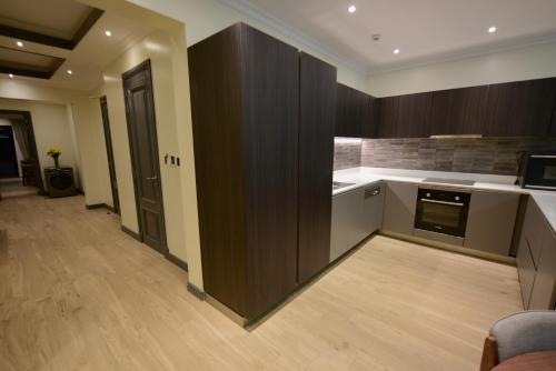 a kitchen with wooden cabinets and a counter top at Fontis Residences Hotel in Kampala