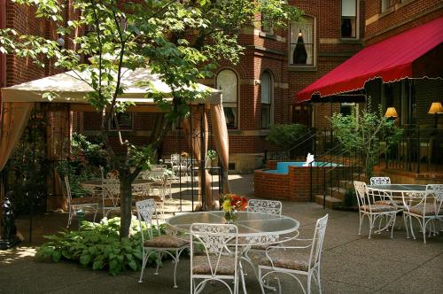 
a patio area with tables, chairs and umbrellas at The Priory Hotel in Pittsburgh

