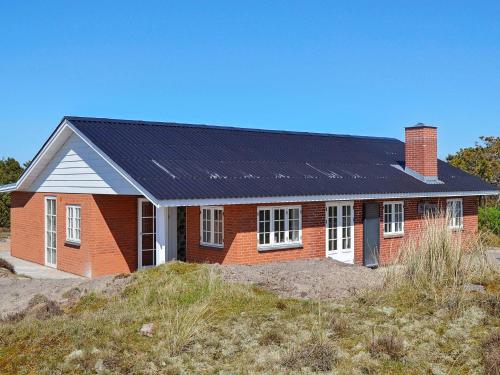 una casa de ladrillo rojo con paneles solares. en 4 person holiday home in Fan, en Fanø