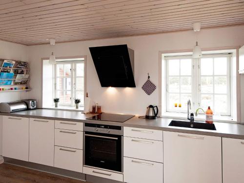 een keuken met witte kasten en een wastafel bij 4 person holiday home in Fan in Fanø