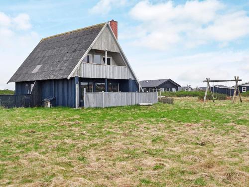 a barn with a gambrel roof in a field at 6 person holiday home in Harbo re in Harboør