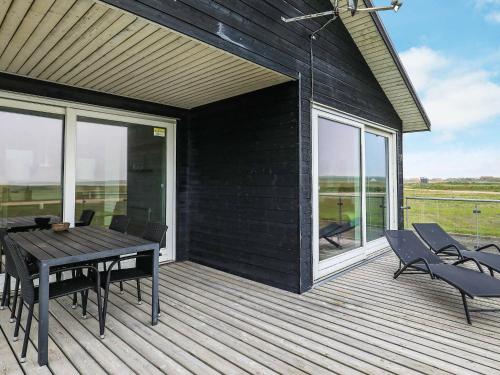 a wooden deck with a table and chairs on it at 4 person holiday home in Harbo re in Harboør