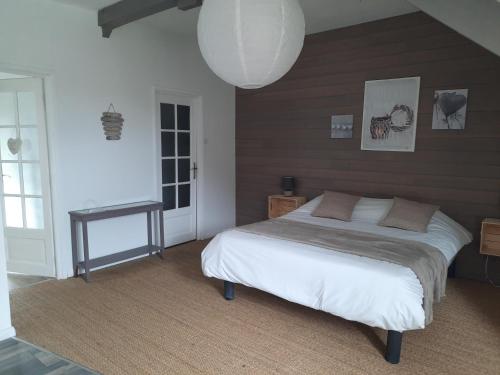 a bedroom with a bed and a table and a lamp at Le clos des sources in Isigny-sur-Mer