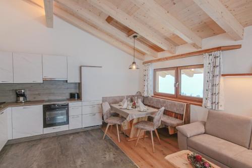 eine Küche und ein Wohnzimmer mit einem Tisch und einem Sofa in der Unterkunft Bamerhof Haus Steger in Mittersill