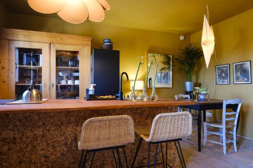 - une cuisine avec un bar avec deux chaises et une table dans l'établissement Finca Martina, à Casarabonela