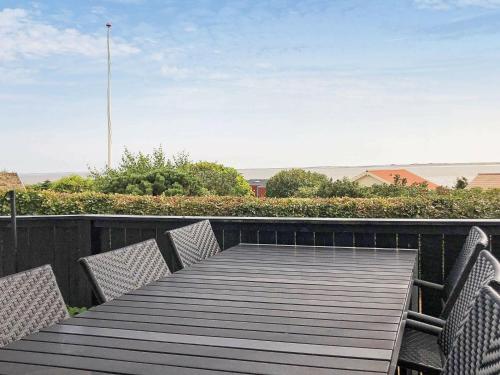 a wooden table and chairs on a deck with a view at 6 person holiday home in Esbjerg V in Esbjerg