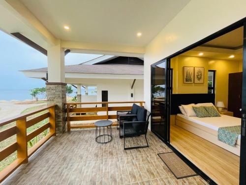a bedroom in a villa with a bed and a balcony at FIG Sunset View Resort in Siquijor