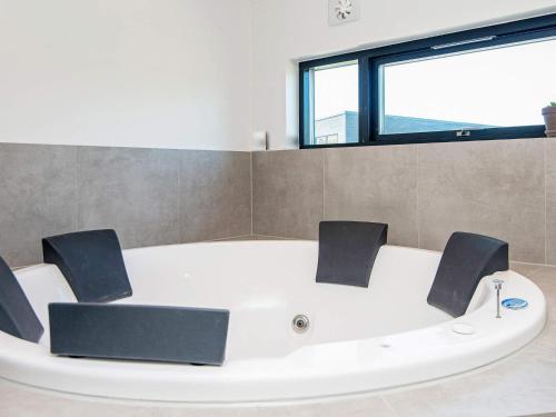 eine weiße Badewanne in einem Zimmer mit Fenster in der Unterkunft 16 person holiday home in Glesborg in Glesborg