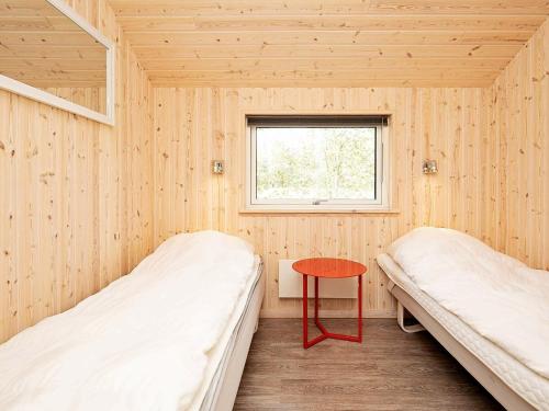 mały pokój z 2 łóżkami i czerwonym stołem w obiekcie Three-Bedroom Holiday home in Broager 4 w mieście Ålbæk