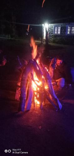 a group of people around a bonfire at night at B2B Home Stay in Kodaikānāl