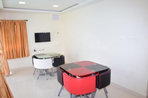 a room with a table and chairs and a tv at B2B Home Stay in Kodaikānāl