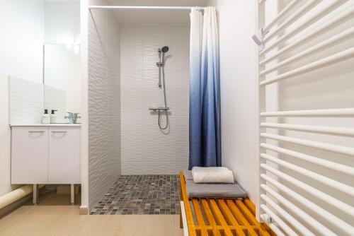 La salle de bains est pourvue d'une douche et d'un banc en bois. dans l'établissement Au 4 le long du canal avec Parking, à Dijon