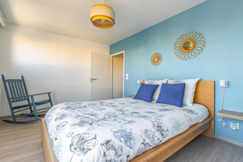 - une chambre avec un lit et un mur bleu dans l'établissement Au 4 le long du canal avec Parking, à Dijon