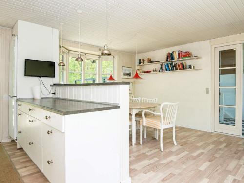 uma cozinha e sala de jantar com uma mesa em 6 person holiday home in Alling bro em Allingåbro