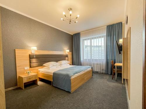 ベロクリハにあるSpa-Hotel&Resort Belovodie with Aquaparkのベッドとテーブルが備わるホテルルームです。