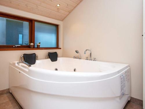 een groot wit bad in een badkamer met een raam bij 6 person holiday home in Tarm in Tarm