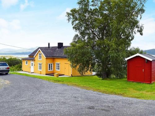 uma casa com um barracão vermelho ao lado de uma estrada em 5 person holiday home in Skutvik em Skutvika