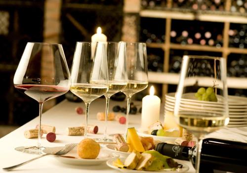 four glasses of wine sitting on a table with food at Hotel Althof Retz in Retz