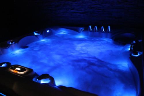 a hot tub with blue lights in a dark room at Zengő Kincse SPA Vendégház Hosszúhetény in Hosszúhétény