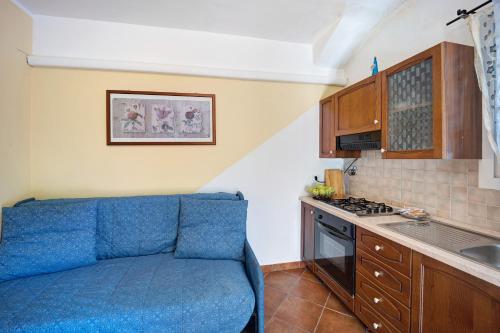 a kitchen with a blue couch in a room at Le Mimose Bilo4 in Imperia