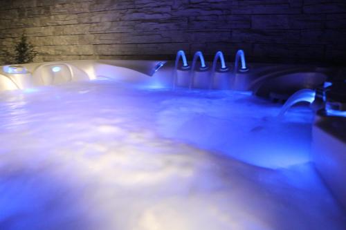 a hot tub with blue lights in a room at Zengő Kincse SPA Vendégház Hosszúhetény in Hosszúhétény