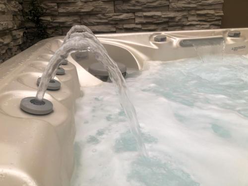a hot tub with water coming out of it at Zengő Kincse SPA Vendégház Hosszúhetény in Hosszúhétény
