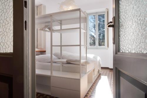 Letto a castello bianco in una camera con finestra di Casa Corten Garden Lago Maggiore a Laveno-Mombello