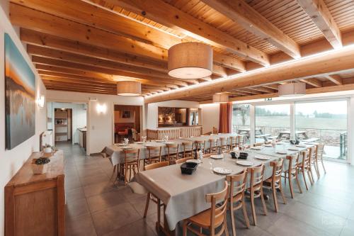 - une salle à manger avec des tables, des chaises et des fenêtres dans l'établissement Le Loup Gris - 35 pers - Vue-Wellness, Butgenbach-Malmedy, à Butgenbach