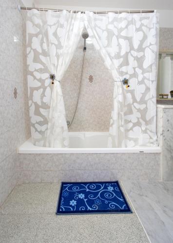 a shower with a blue and white shower curtain at La terra dei sogni in Marsala