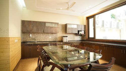 a kitchen with a glass table and chairs at UDS Villa Scandinavian B&B - Next to VFS in New Delhi
