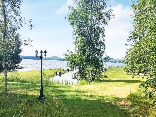 a lamp post in the grass near a body of water at 6 person holiday home in GRANG RDE in Grangärde