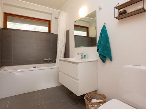a bathroom with a sink and a toilet and a mirror at 14 person holiday home in Sj llands Odde in Tjørneholm