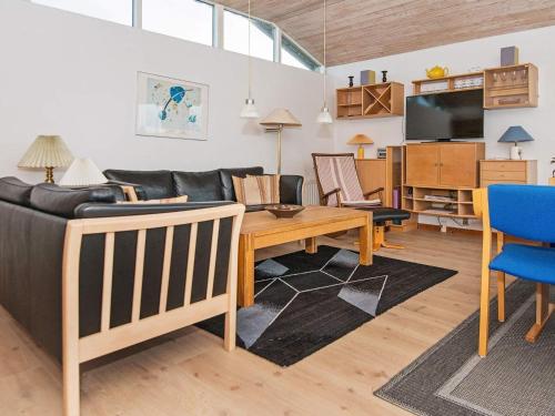 a living room with a couch and a table at 6 person holiday home in R nde in Rønde