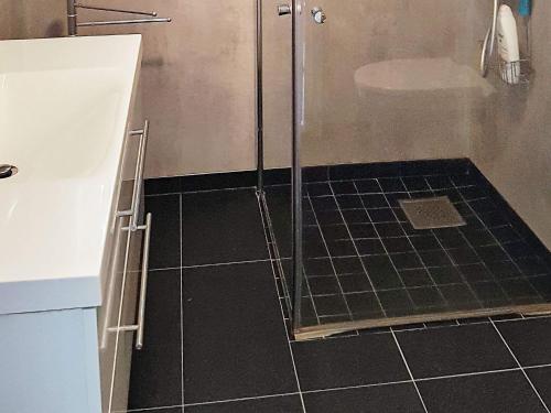 baño con ducha y suelo de baldosa negra. en Holiday home Brattvåg, en Brattvåg