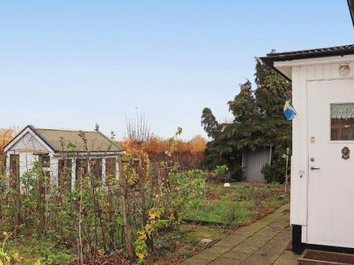 a garden in front of a white shed at 6 person holiday home in SIMRISHAMN in Simrishamn