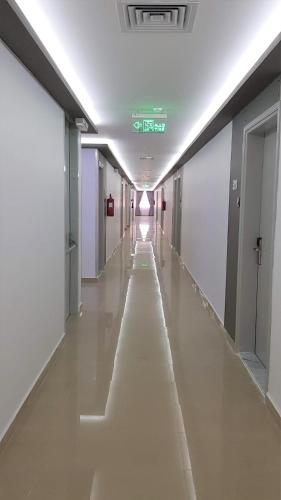 an empty hallway in a building with a long aisle at Nova Park Hotel in Sharjah
