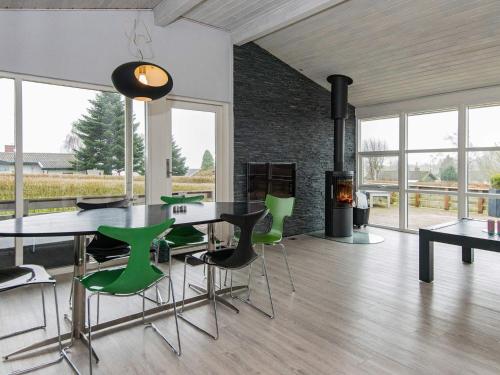 uma sala de jantar com uma mesa e cadeiras verdes em 6 person holiday home in Hejls em Hejls