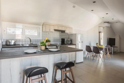a kitchen with a counter and some chairs in it at Fidias city rooms in Argostoli