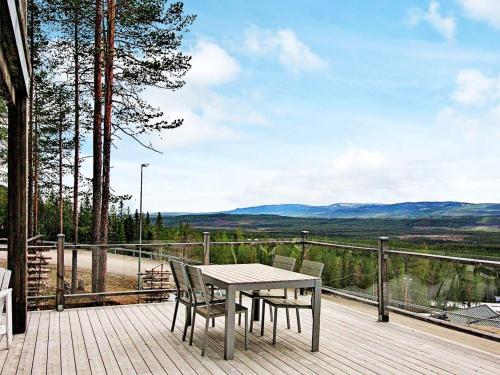 a table and chairs on a wooden deck with a view at 8 person holiday home in VEMDALEN in Vemdalen