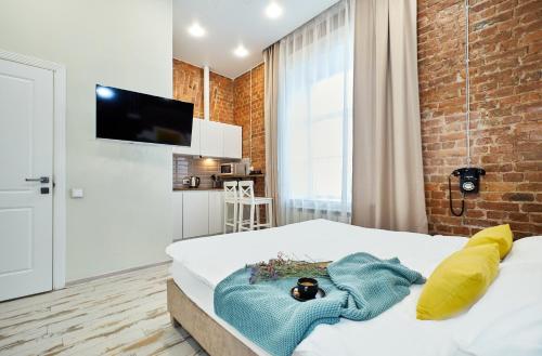 a bedroom with a bed and a brick wall at GrandWhite Apart in Saint Petersburg
