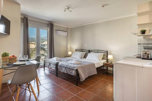 a bedroom with a bed and a table and a kitchen at Fidias city rooms in Argostoli