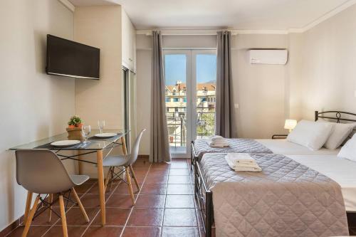 a hotel room with a bed and a table and chairs at Fidias city rooms in Argostoli