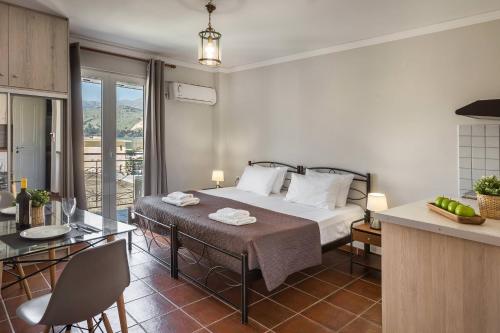 a bedroom with a bed and a kitchen with a table at Fidias city rooms in Argostoli