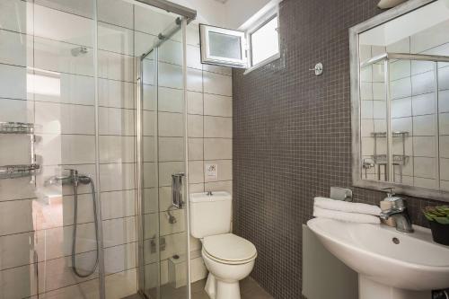 a bathroom with a toilet and a sink and a shower at Fidias city rooms in Argostoli