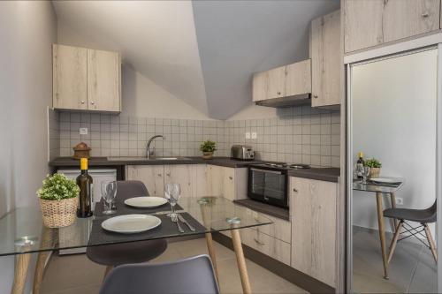 a kitchen with a glass table and chairs in a room at Fidias city rooms in Argostoli